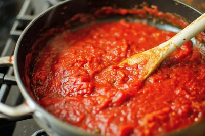 Wooden Spoon Stirring Tomato Sauce In A Pan