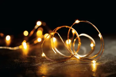 Glowing Fairy Lights Coiled on Dark Textured Surface