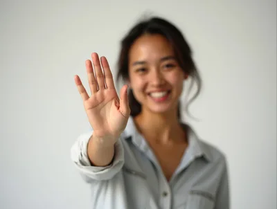 Young Asian Woman Holding Up Hand In Stop Gesture