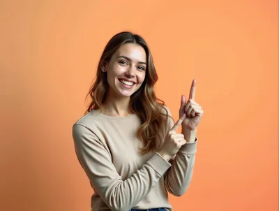 Smiling Young Woman Pointing Upwards Against Orange Background