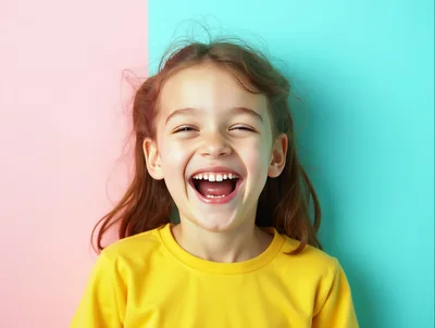 Happy Young Girl Laughing Against Two Tone Background