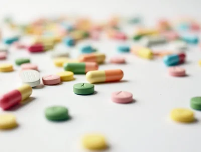 Assorted Colorful Pharmaceutical Pills Scattered on White Surface