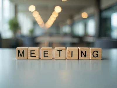 Wooden Blocks Spelling Meeting On A Blurred Office Desk