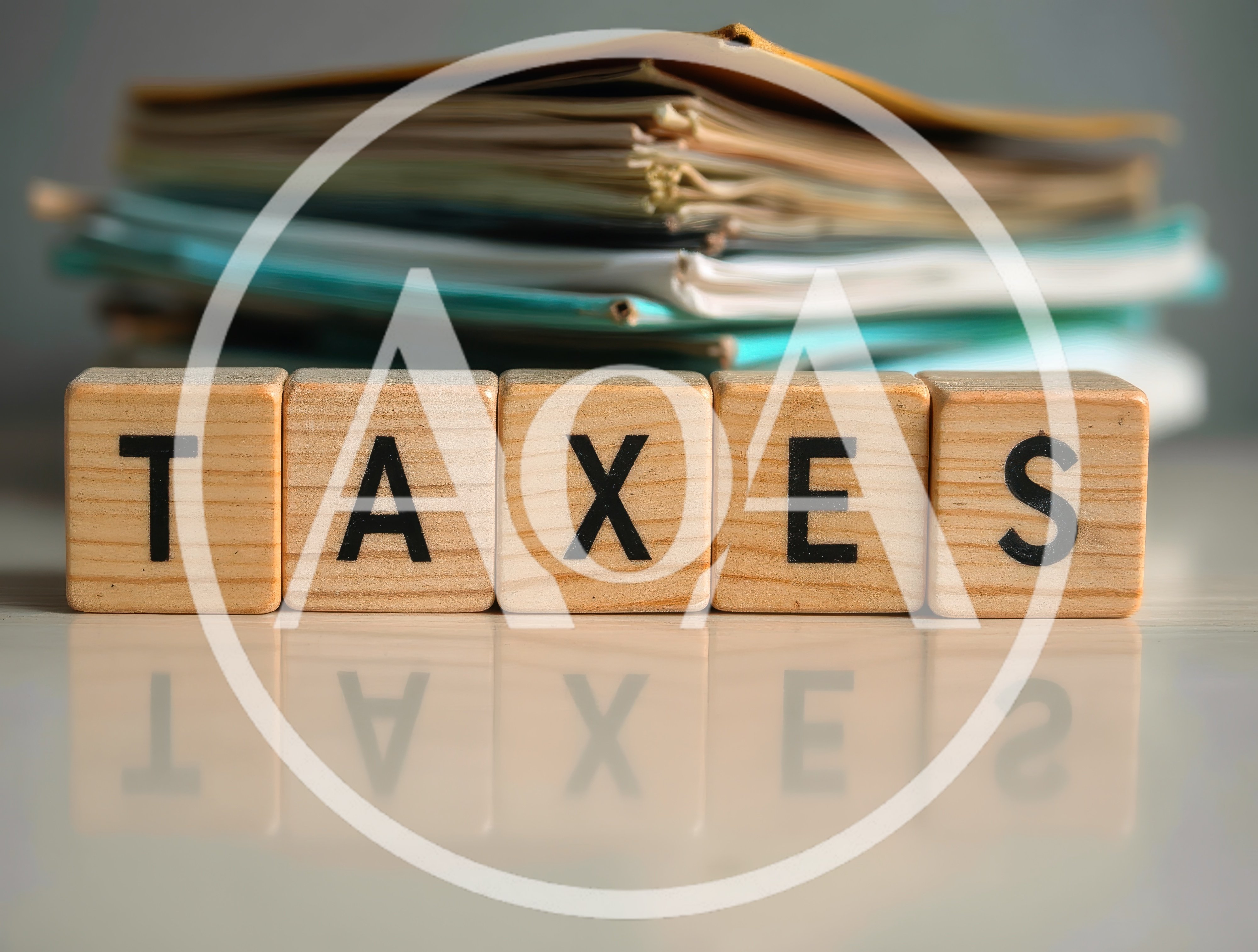 Wooden Blocks Spelling Taxes With Stacked Paperwork