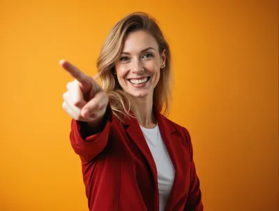 Smiling Businesswoman Pointing Forward Against Yellow Background
