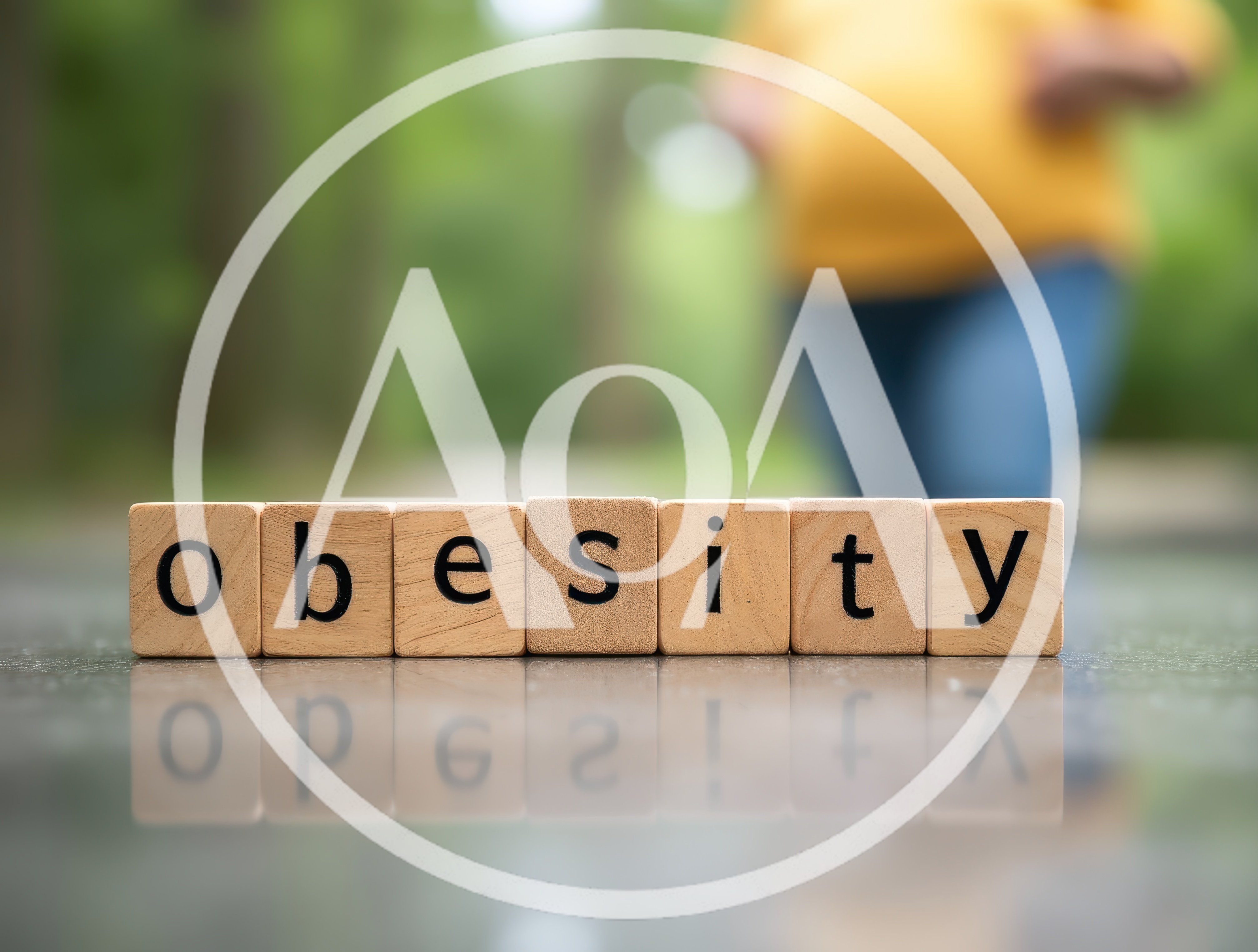 Wooden Blocks Spelling Obesity With Blurred Person In Background