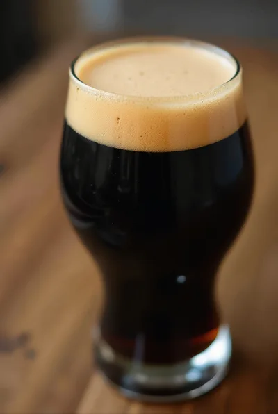 Glass Of Dark Stout Beer On Wooden Table