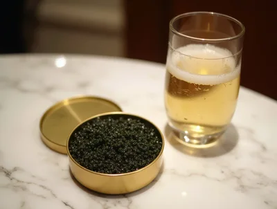 Caviar Tin And Glass Of Champagne On Marble Table