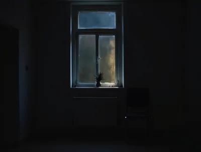 Dark Room With A Single Window And Chair