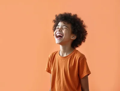 Happy Young Boy Laughing With Eyes Closed