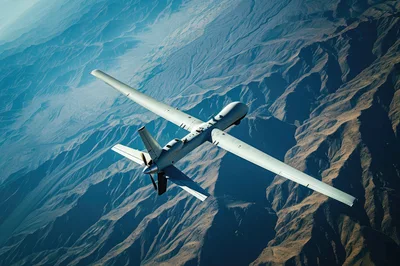 MQ-9 Reaper Drone Flying Over Rugged Mountain Terrain