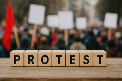 Wooden Blocks Spelling Protest Against Blurred Crowd Background