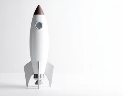 White Toy Rocket Ship Standing On White Background