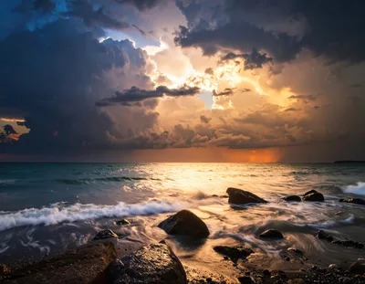 Dramatic Sunset Over Rocky Ocean Shoreline