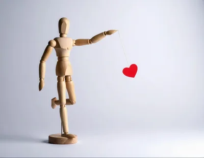 Wooden Mannequin Holding A Red Heart