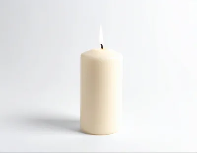 Lit Cream Pillar Candle On White Background