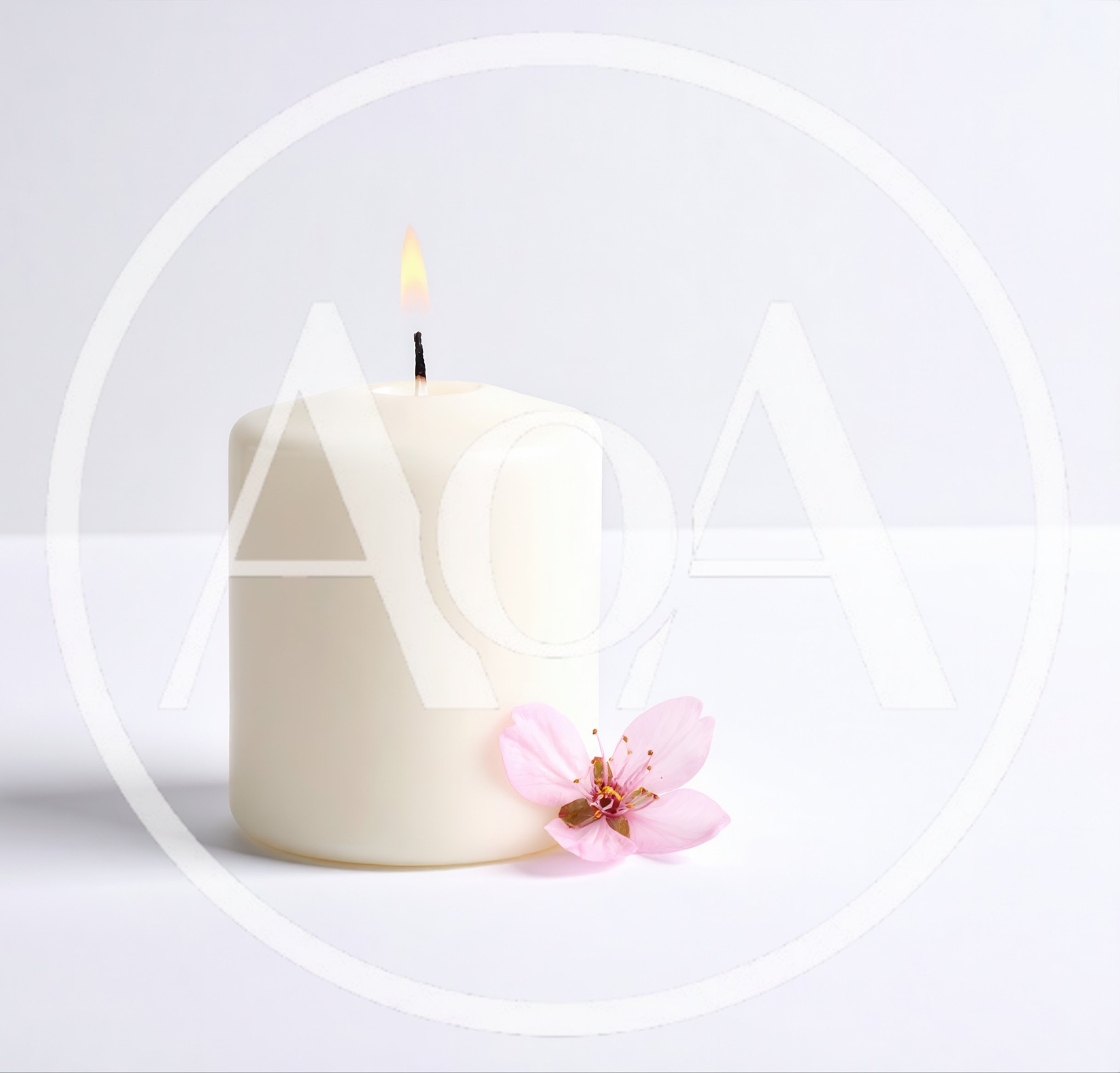 Lit White Pillar Candle With A Pink Cherry Blossom