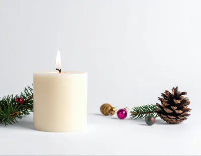 Lit Pillar Candle With Christmas Decorations