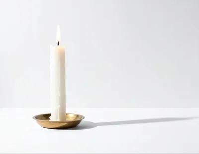Lit White Candle In A Brass Holder