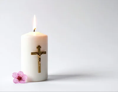 Lit White Candle With Crucifix And Pink Flower