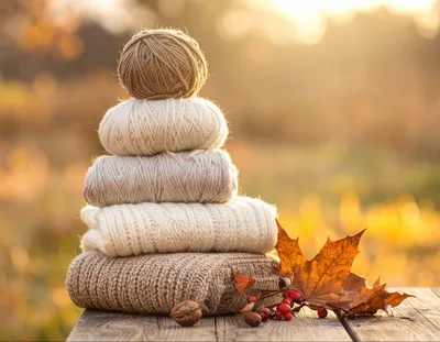 Stack Of Knitted Sweaters And Yarn Balls