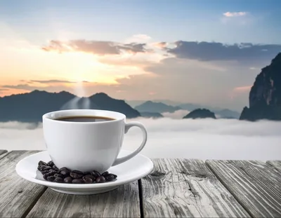 Coffee Cup on Wooden Table Overlooking Misty Mountains