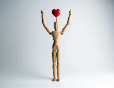 Wooden Mannequin Holding A Red Heart