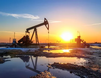 Oil Pump Jack Operating At Sunset