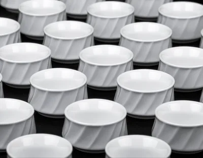 Rows of White Ceramic Bowls on Black Background