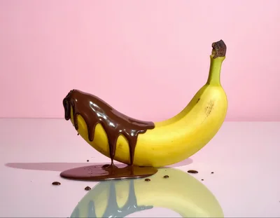Banana Covered In Melting Chocolate On Pink Background