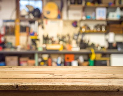 Wooden Table Surface In A Blurred Workshop Background