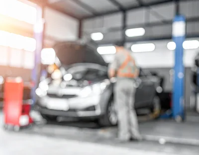 Mechanic Working on Car in Auto Repair Shop