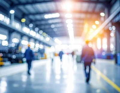 Blurred Factory Workers Walking Through Industrial Warehouse