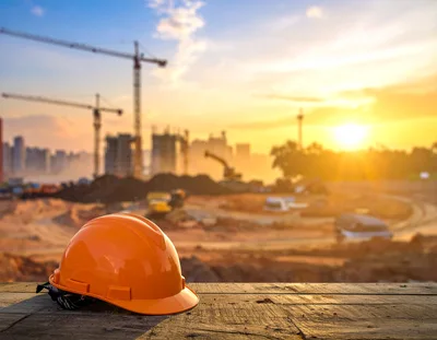 Orange Hard Hat On Wooden Surface At Construction Site