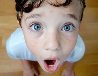 Surprised Young Boy Looking Up With Wide Eyes