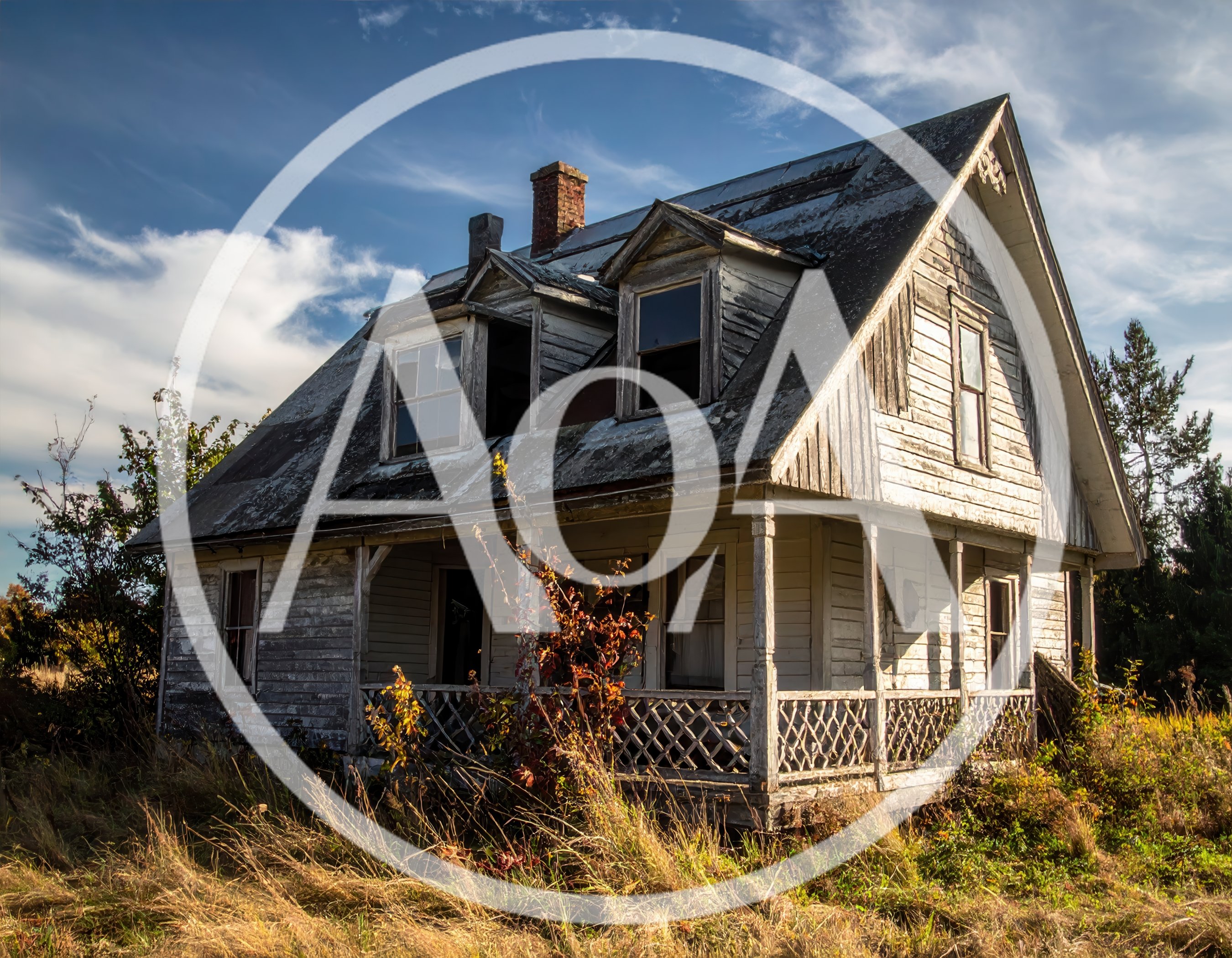 Abandoned Weathered Farmhouse In A Grassy Field