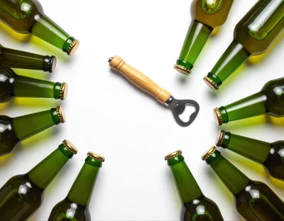 Green Beer Bottles Arranged Around A Bottle Opener