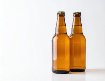 Two Amber Glass Beer Bottles On White Background