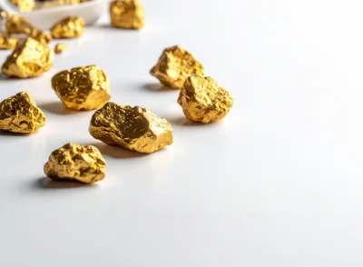 Scattered Gold Nuggets on a White Surface
