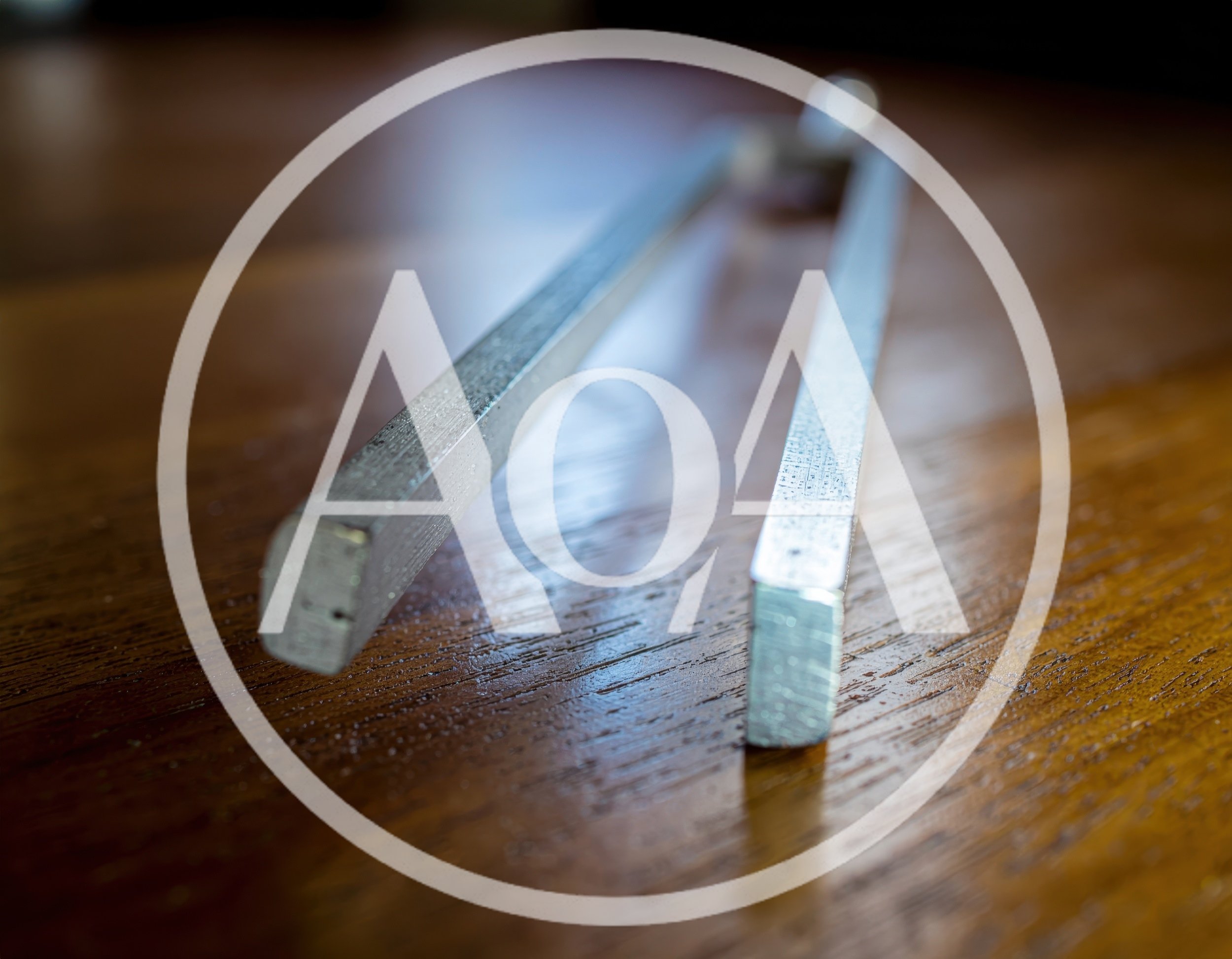 Metal Tuning Fork Resting On Wooden Table