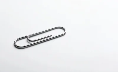 Single Silver Metal Paperclip On White Background