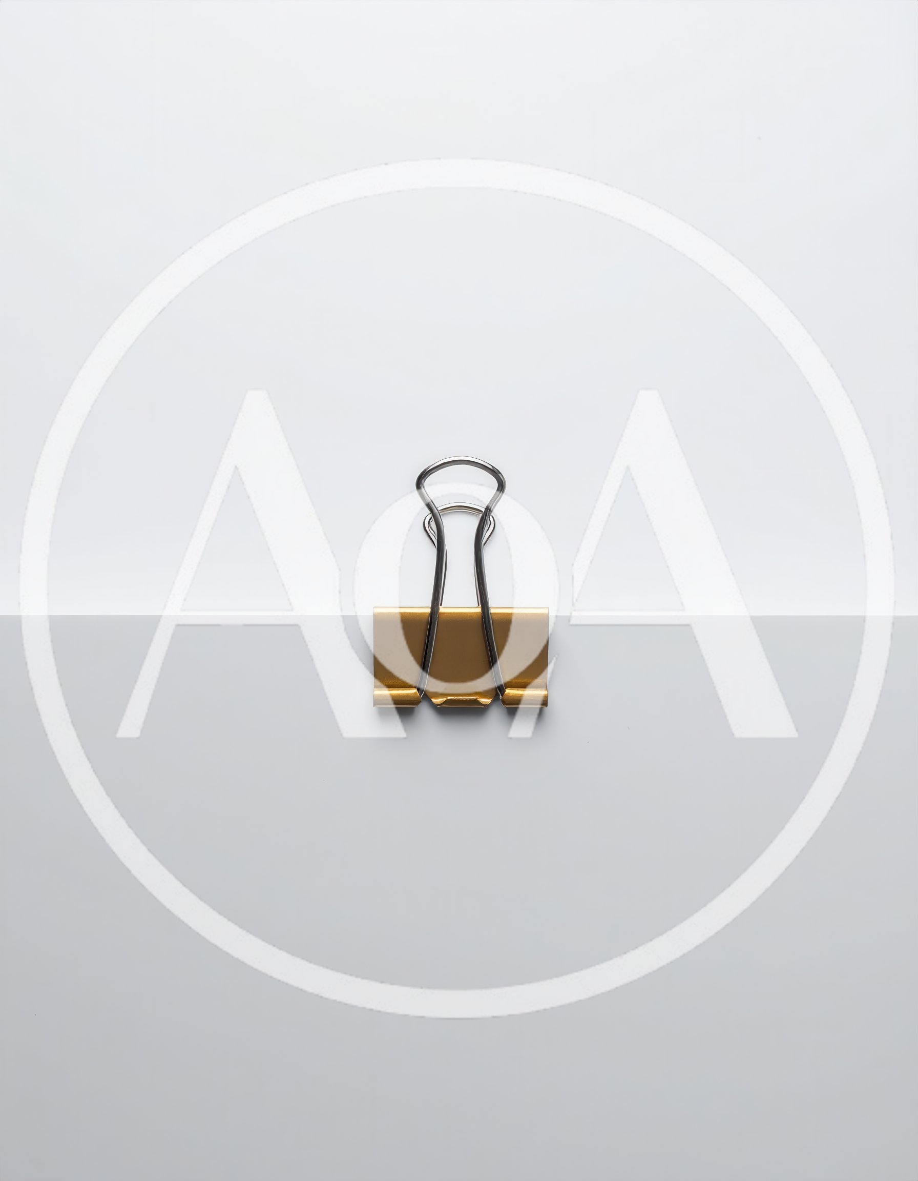 Gold Binder Clip Holding White Paper