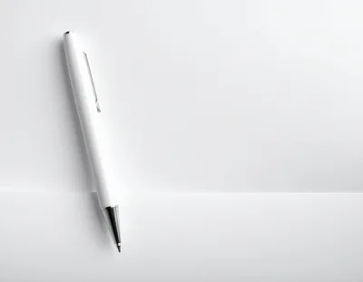 White Ballpoint Pen Resting On Blank Paper