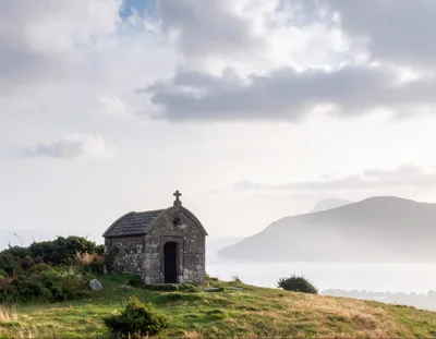 Small Stone Chapel Overlooking A Misty Coastal Landscape
