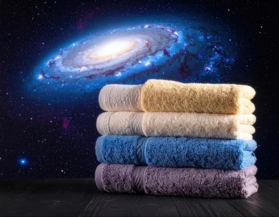 Stack Of Folded Colorful Towels Against A Galaxy Background
