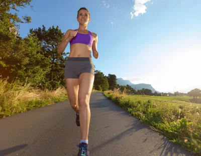 Woman Jogging on a Country Road at Sunset