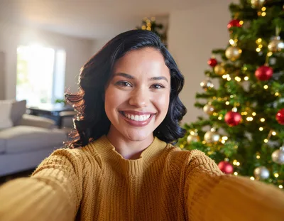 Young Woman Taking A Selfie In Front Of Christmas Tree