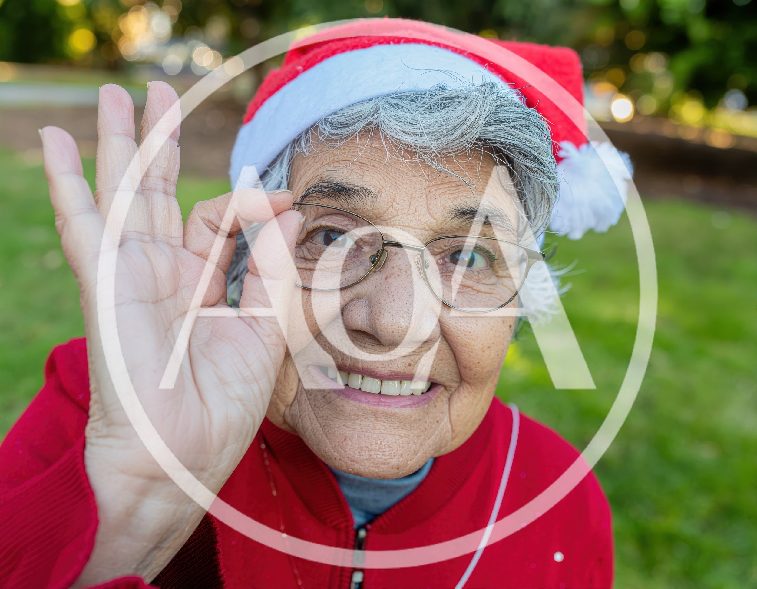 Senior Woman Wearing Santa Hat Making OK Gesture