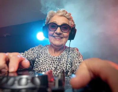 Elderly Woman DJ Playing Music In Nightclub