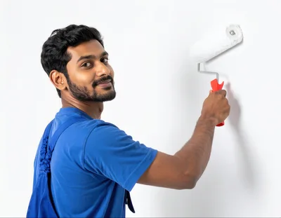 Young Man Painting A White Wall With A Roller